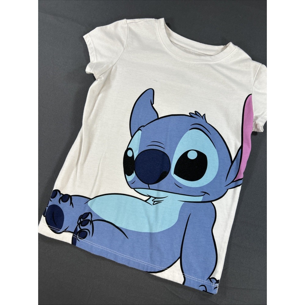 white short-sleeve baby tee featuring a playful graphic of Stitch